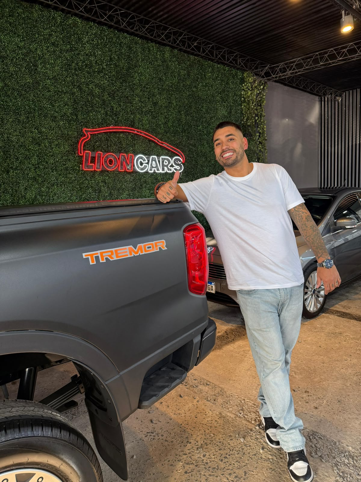 Dueño de Lion Cars saludando junto a una Ford Ranger Tremor en el showroom